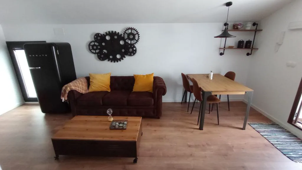 Salón con sofá marrón y mesa de madera