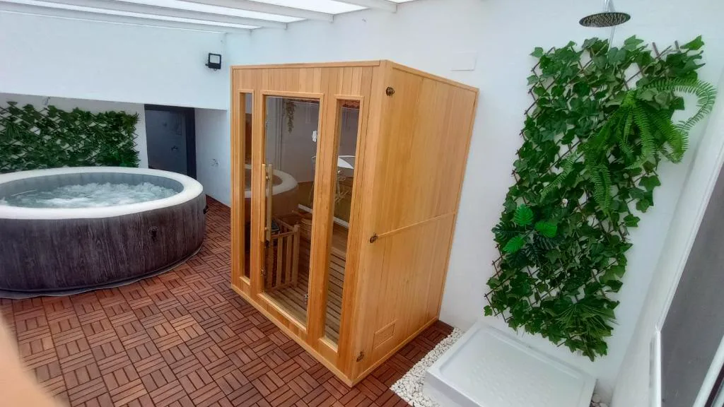 Sauna de madera junto a un jacuzzi
