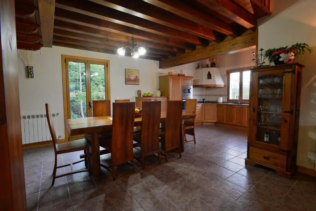 Cocina comedor con vigas de madera y mesa larga
