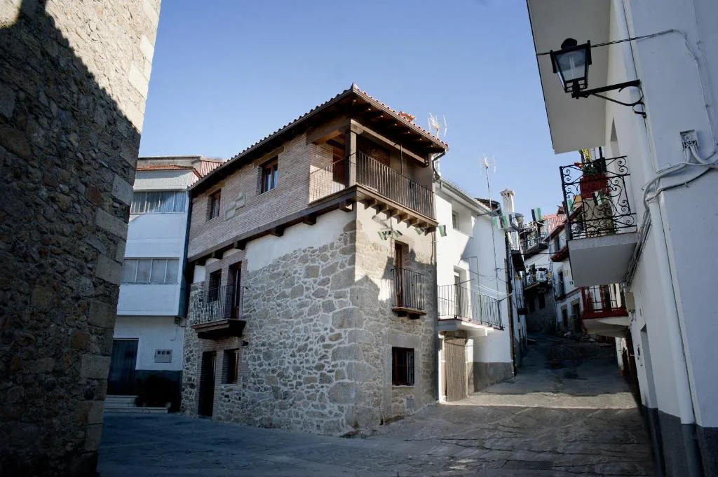 Calle empinada con casas de piedra y balcones de madera