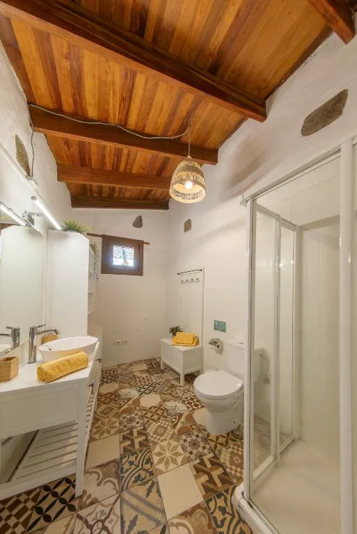 Baño con doble lavabo blanco y suelo de baldosa hidráulica geométrica, Casa Rural Bentayga