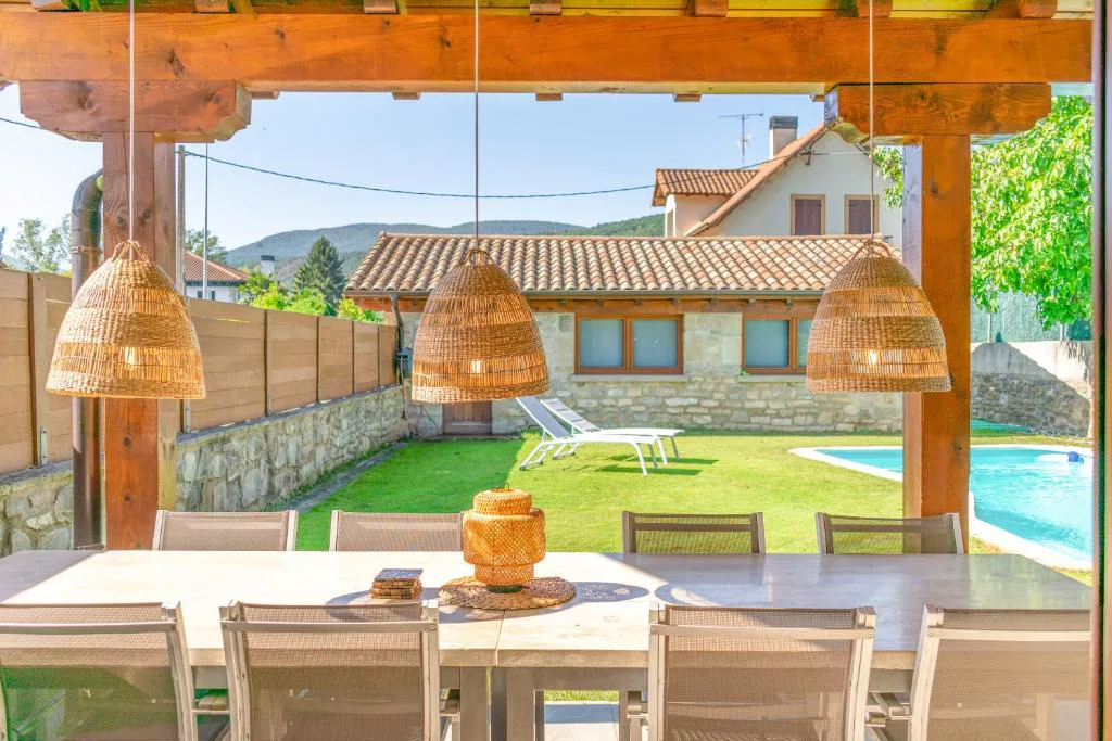 Porche de madera con mesa junto a la piscina