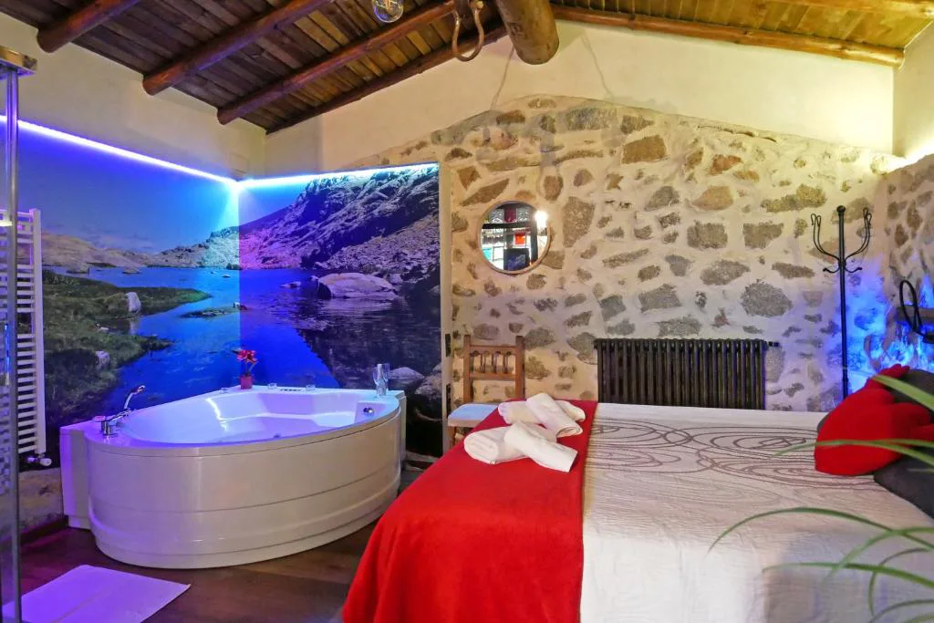 Dormitorio con jacuzzi, pared de piedra y luz azul