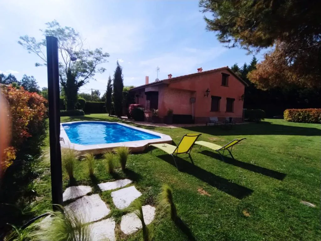 Piscina con tumbonas junto a la casa