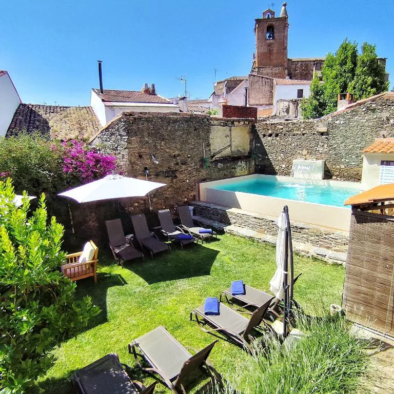 Patio con jardín y piscina entre casas de piedra