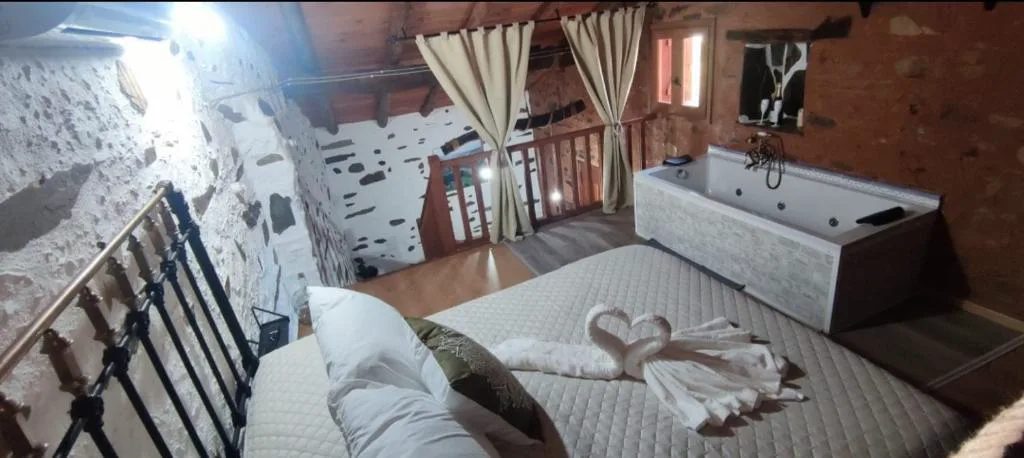 Bañera de hidromasaje blanca en una habitación con vigas