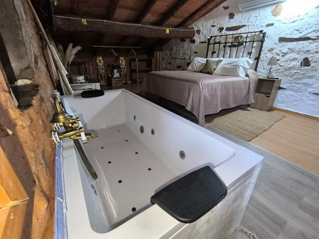 Bañera de hidromasaje junto a una cama
