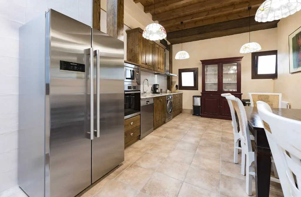 Cocina con nevera de acero y mesa