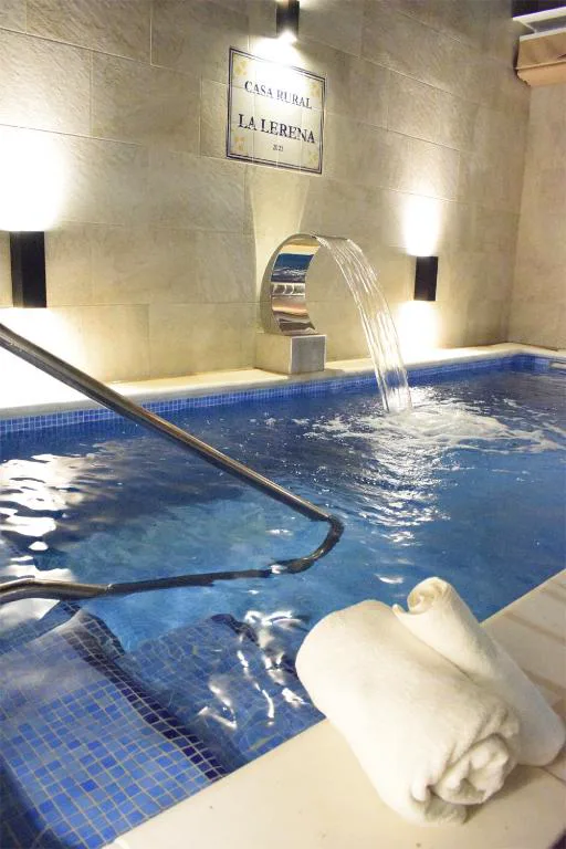 Piscina pequeña con toallas junto a una pared iluminada