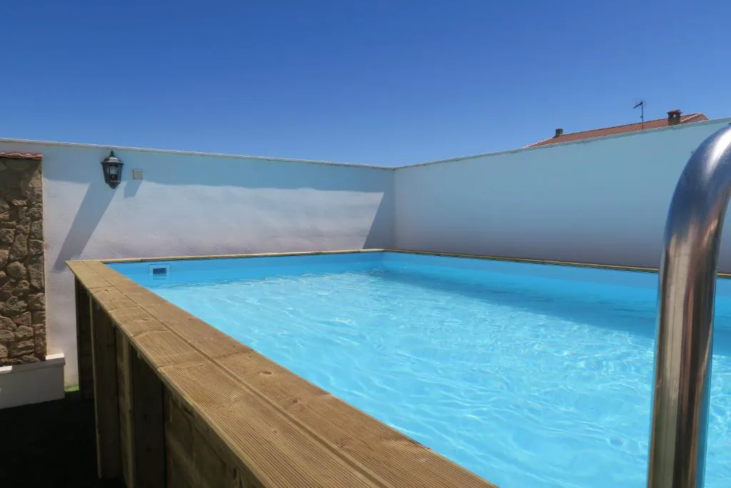Piscina elevada de madera con vistas al jardín