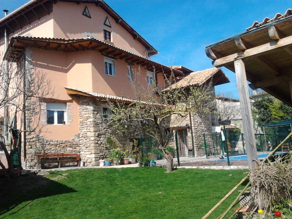 Casa de ladrillo con jardín y árboles