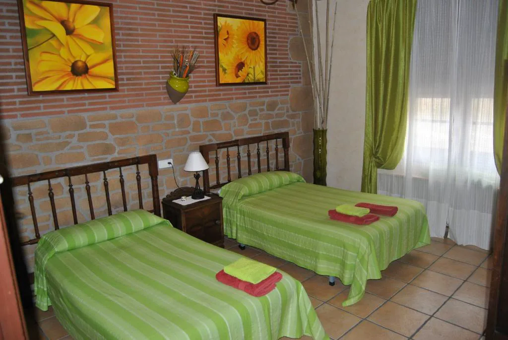 Habitación con camas individuales y cabeceros verdes