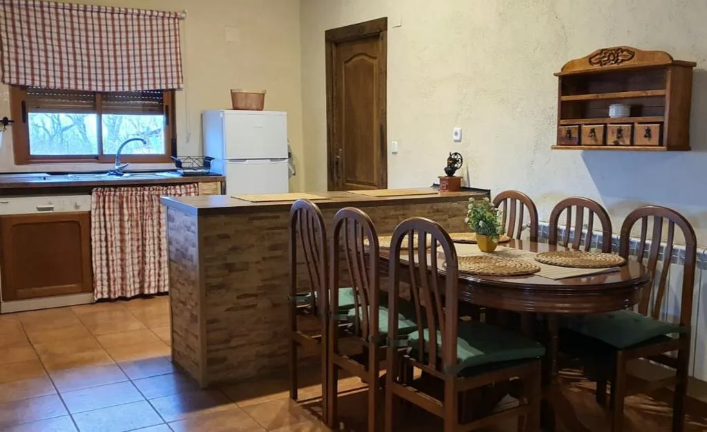 Cocina comedor con mesa y sillas de madera