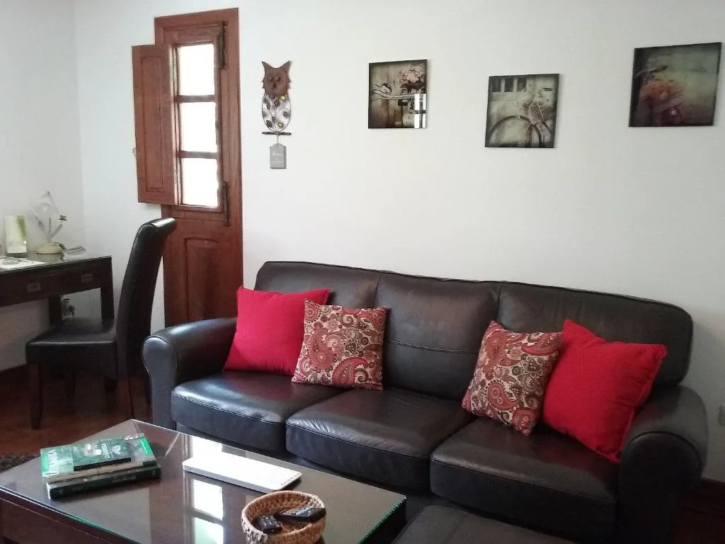 Salón con sofá de cuero y cojines de estampado paisley, Casa Rural Llano Campo