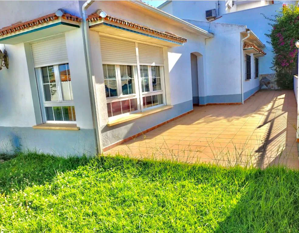 Casa blanca con jardín de césped