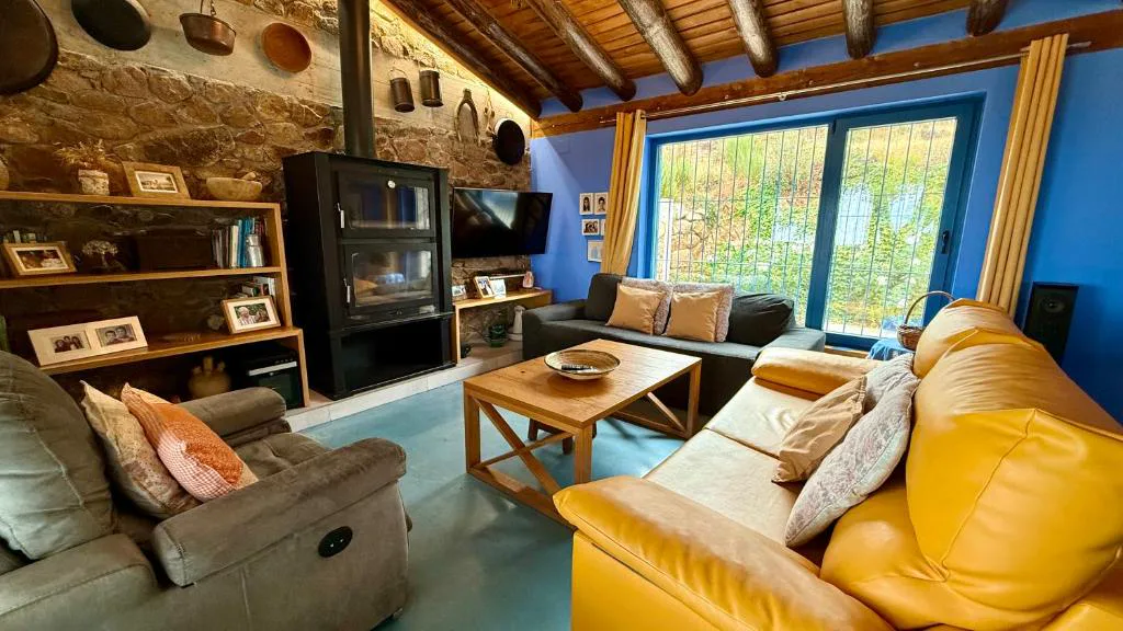 Salón con sillones y ventanas sobre el jardín