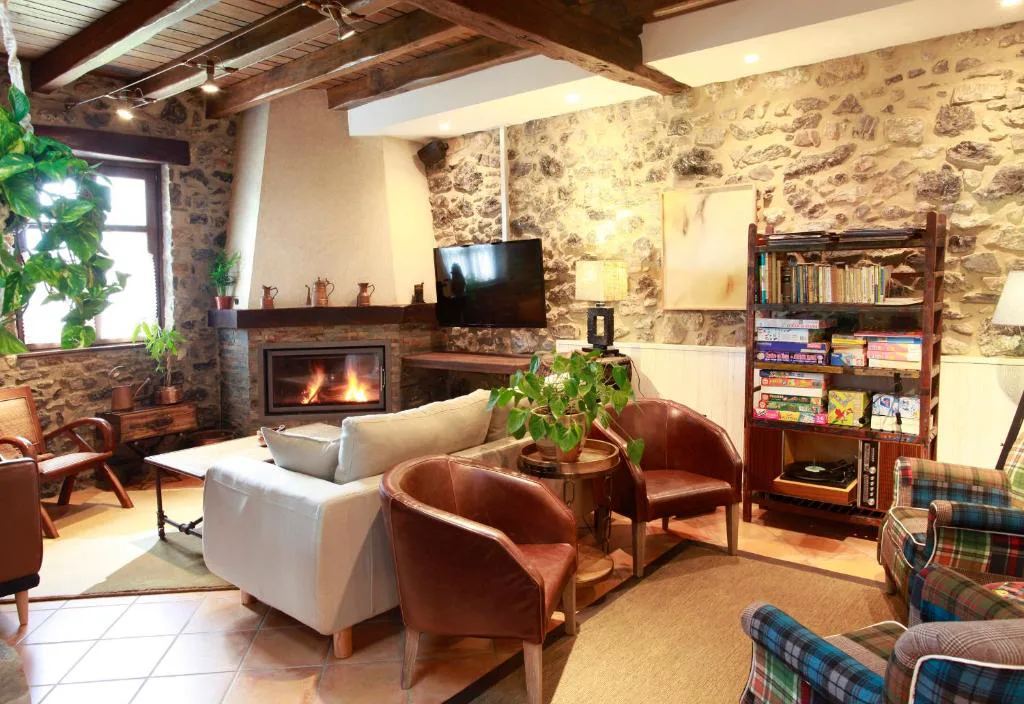 Salón con chimenea encendida y sillones de cuero