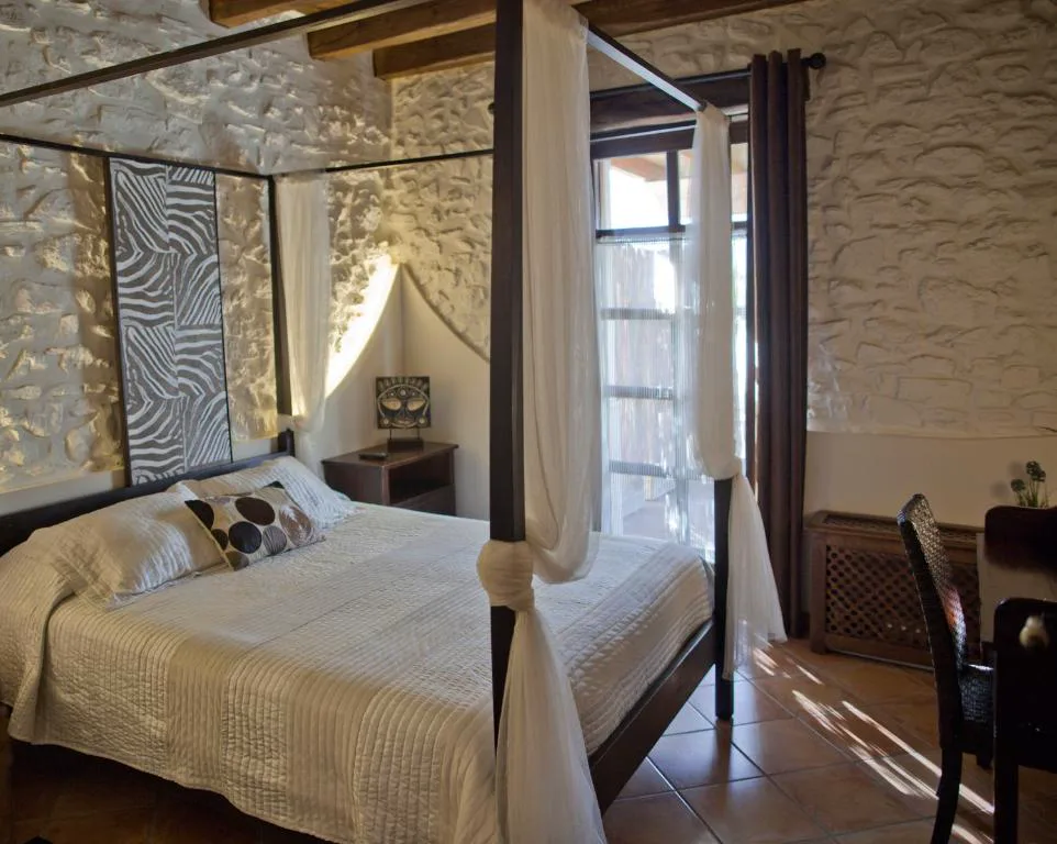 Habitación con dosel y pared de piedra