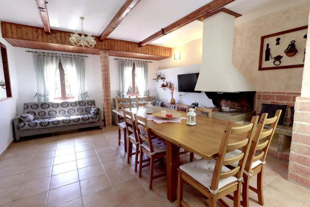 Salón comedor con mesa larga y chimenea