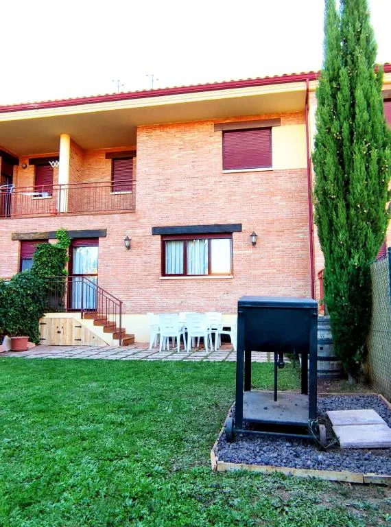 Chalet de ladrillo con jardín y barbacoa