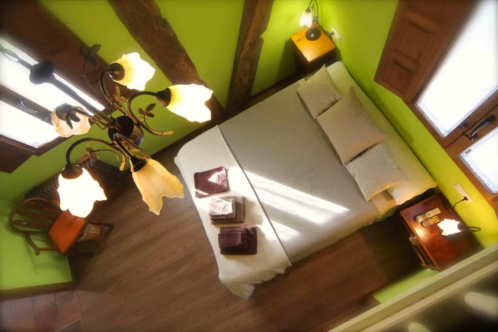 Dormitorio con paredes verdes y vigas de madera