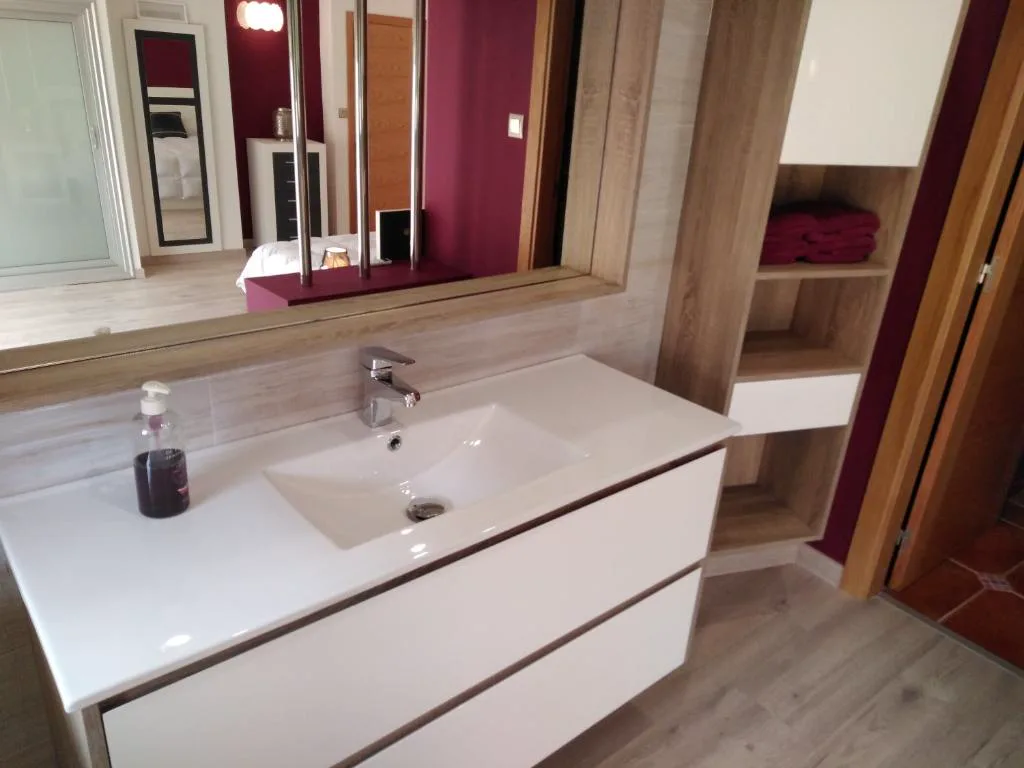 Baño moderno con encimera blanca y toallas granate, Casa Spa en Montaña