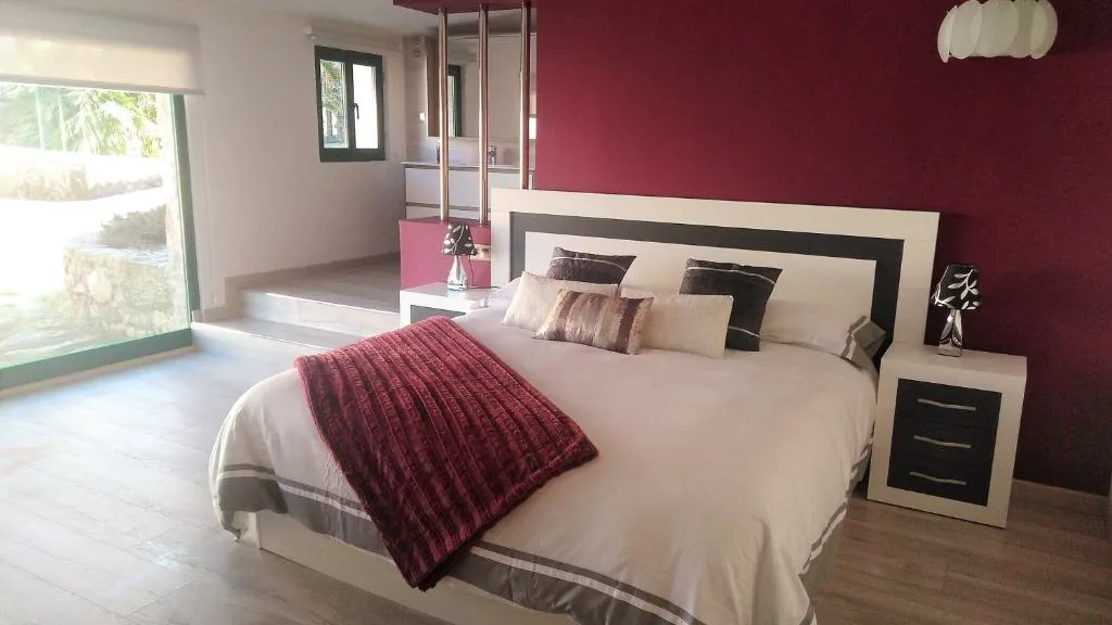 Dormitorio principal con cabecero granate y vistas al jardín, Casa Spa en Montaña