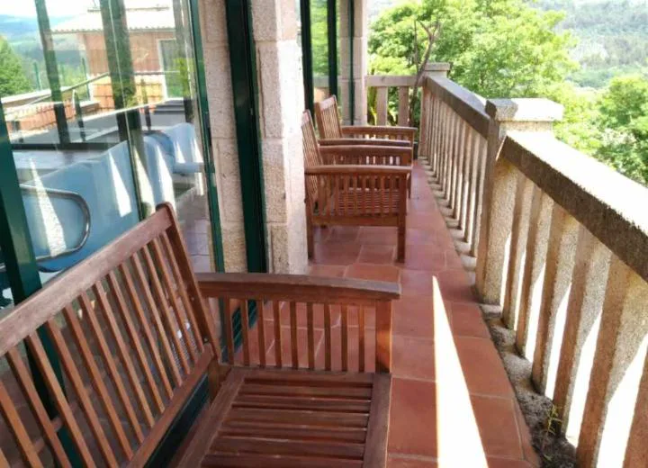 Terraza con bancos de madera junto a la piscina interior y vistas al valle, Casa Spa en Montaña