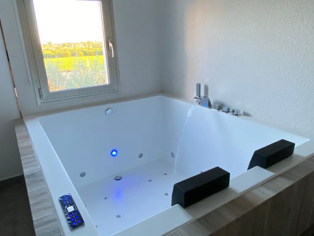 Bañera de hidromasaje grande con luces azules y asientos negros