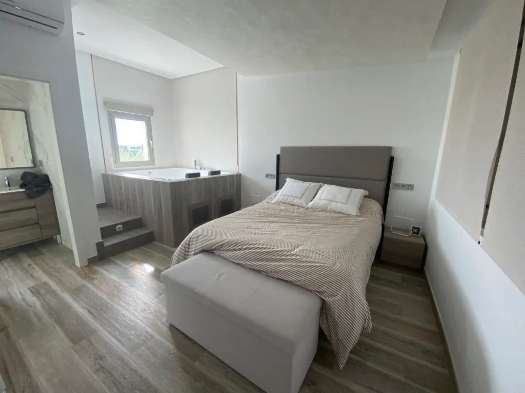 Habitación con cabecero gris y cama doble