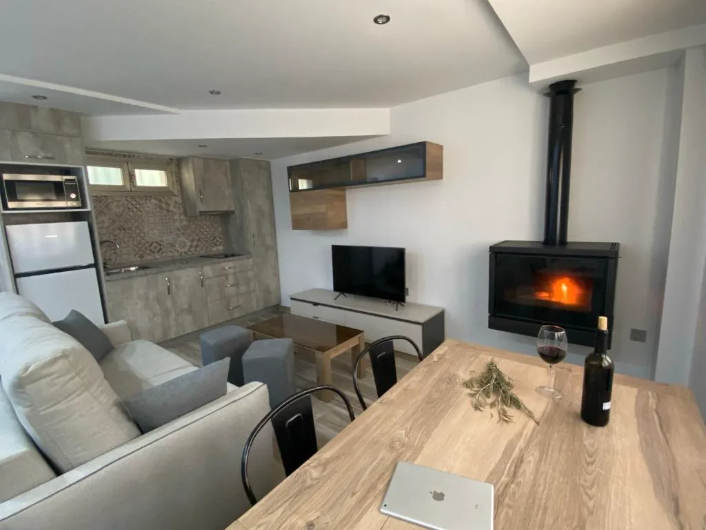 Salón con estufa de leña encendida y mesa de madera