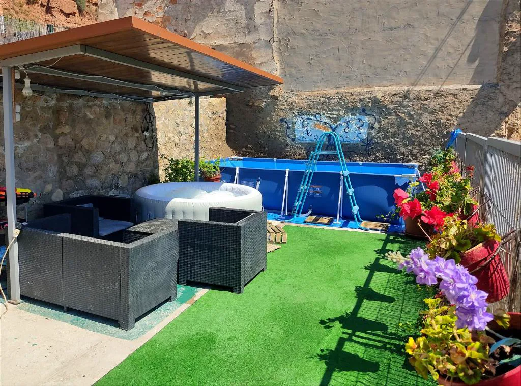 Piscina desmontable en un jardín con sofás de exterior