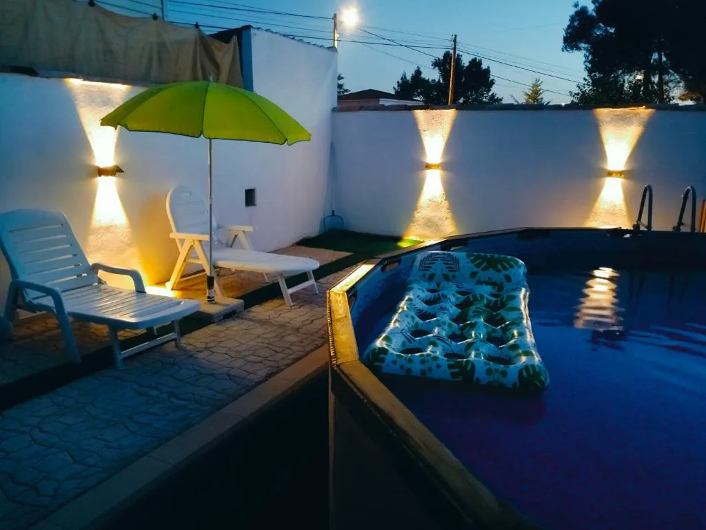 Piscina con tumbonas y tumbona flotante de noche