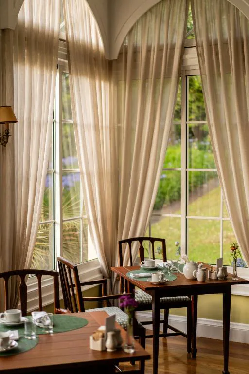 Sala del desayuno con ventanales de arco y vistas al jardín, Casa Velha do Palheiro