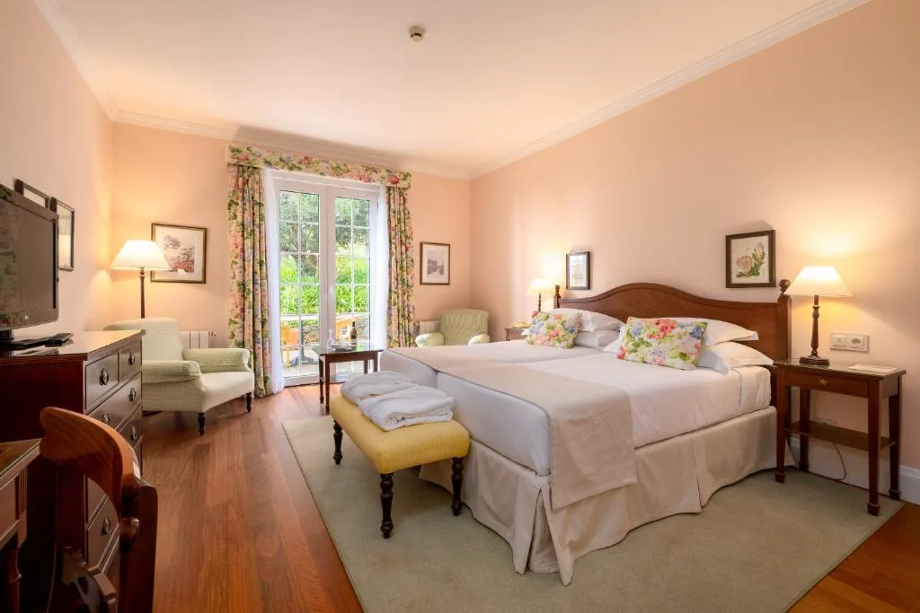 Habitación clásica en tonos rosas con cortinas florales, Casa Velha do Palheiro
