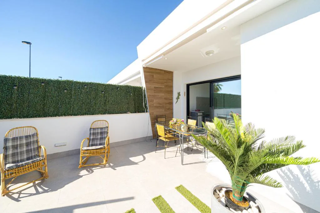 Patio con sillones de mimbre y palmera