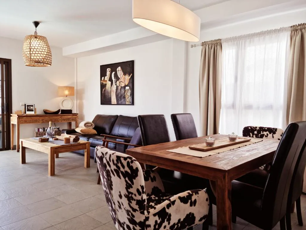 Salón comedor con sillas de estampado animal y mesa de madera maciza, Casa Volcanes