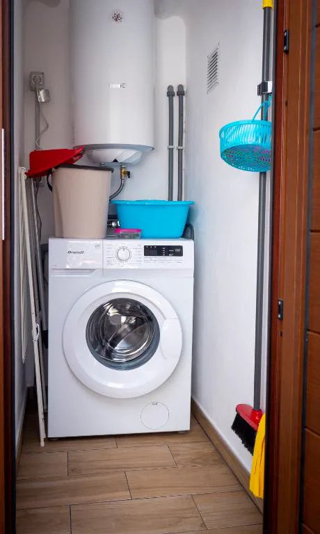Cuarto de lavado integrado con electrodomésticos blancos, Casa volcánica El Cabezo