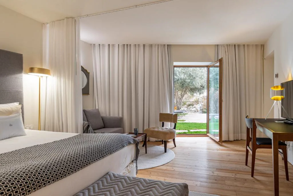 Suite con puertas abiertas al jardín y vistas a un olivo, Casas da Lapa