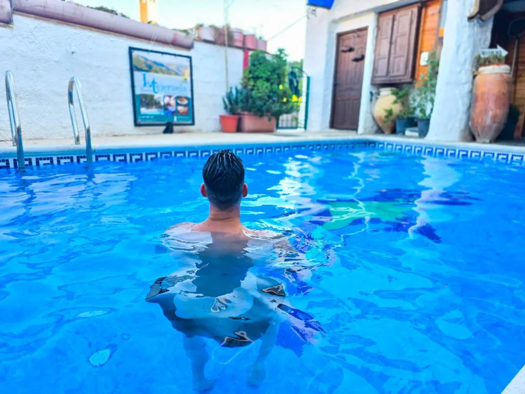 Persona nadando en una piscina de azulejos azules