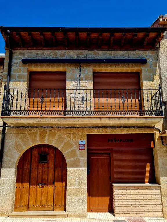 Fachada de piedra con balcón y puerta de madera