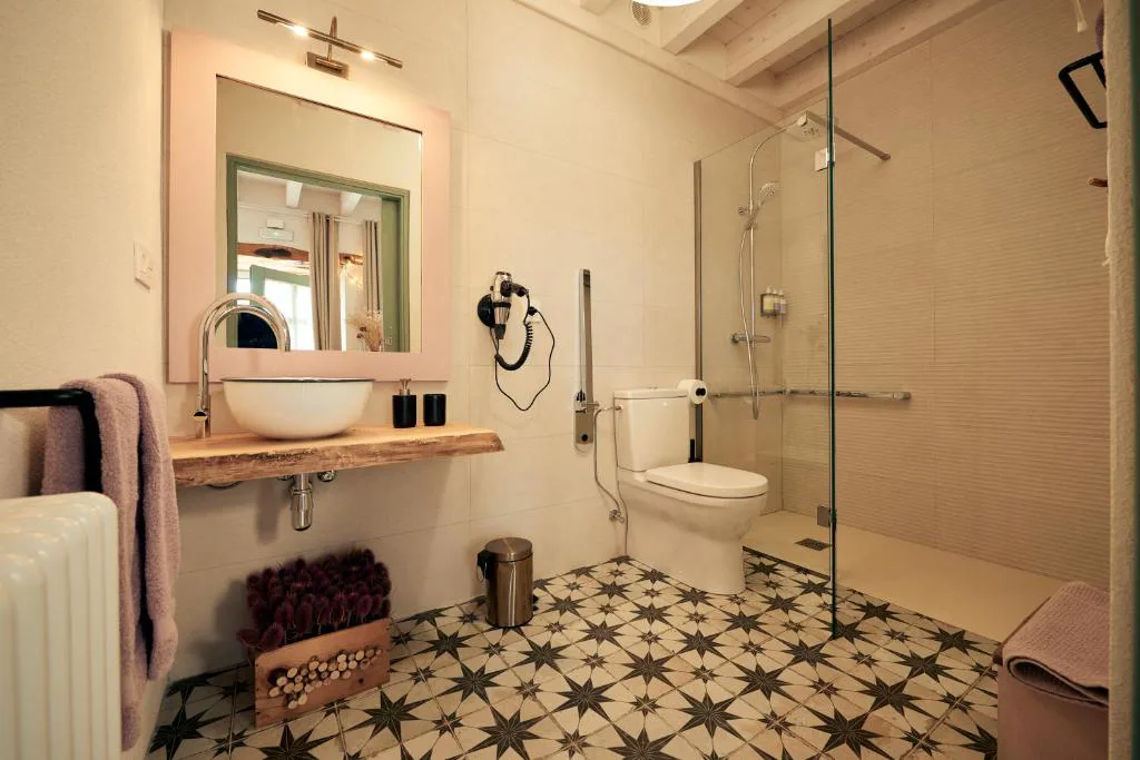 Baño con ducha de cristal y lavabo sobre encimera