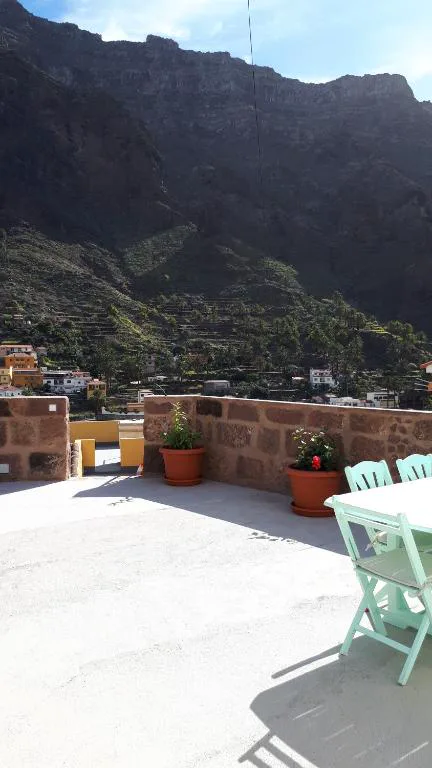 Terraza en la azotea con mesa y sillas frente al gran anfiteatro de montañas de Valle Gran Rey, Casita Tio Manuel