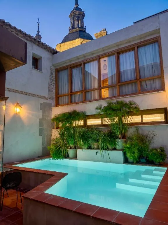 Piscina azul en un patio de un casón con balcones