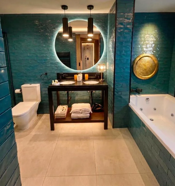 Baño con bañera y lavabo redondo verde