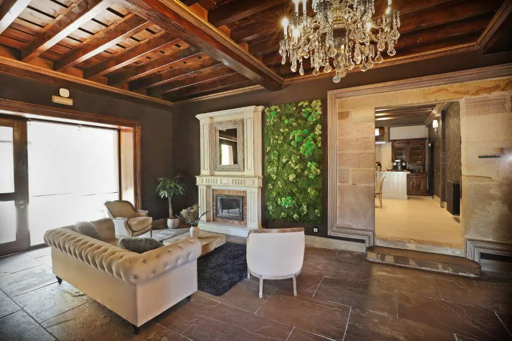 Salón con chimenea, sofás claros y techo de madera