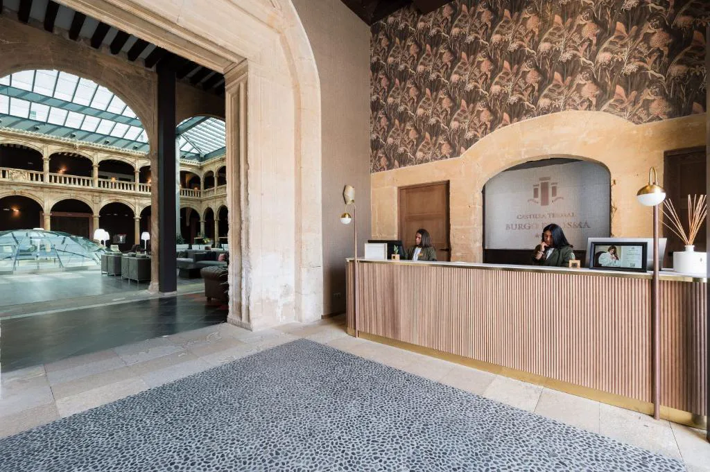 Recepción con arco de piedra junto al patio acristalado