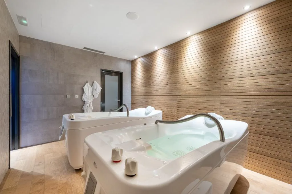 Cabina de baños con dos bañeras de hidromasaje y paneles de madera