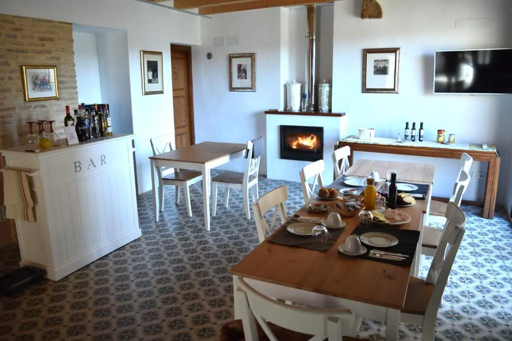 Salón con mesa, cocina y chimenea