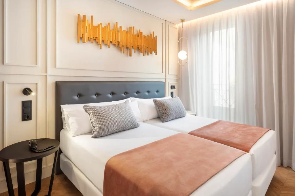 Habitación con cabecero acolchado y ropa de cama rosa